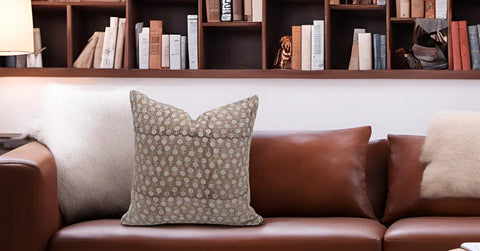 Brown leather couch with unique throw pillows enhancing living space decor.